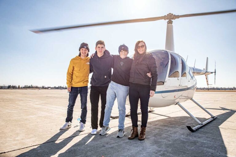 Friends posing in front of helicopter