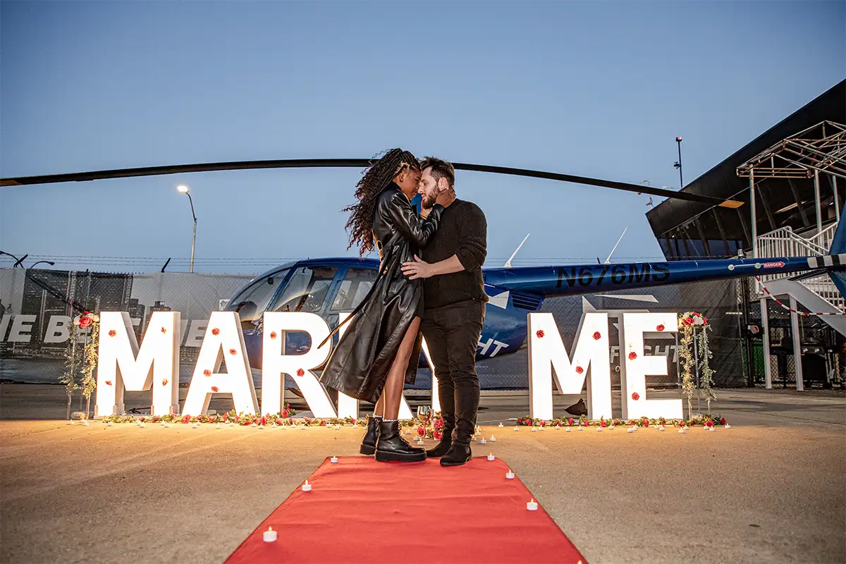 a man and a woman embrace during a helicopter proposal at myflight tours detroit