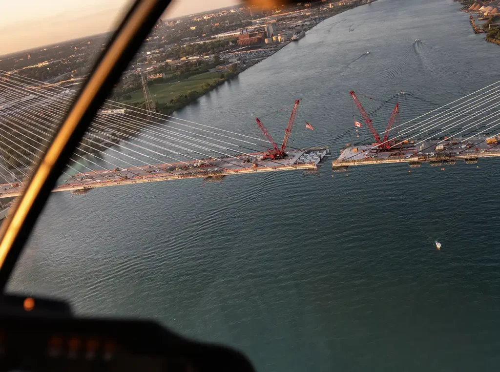 a sunset of the almost complete detroit gordie howe bridge from a helicopter