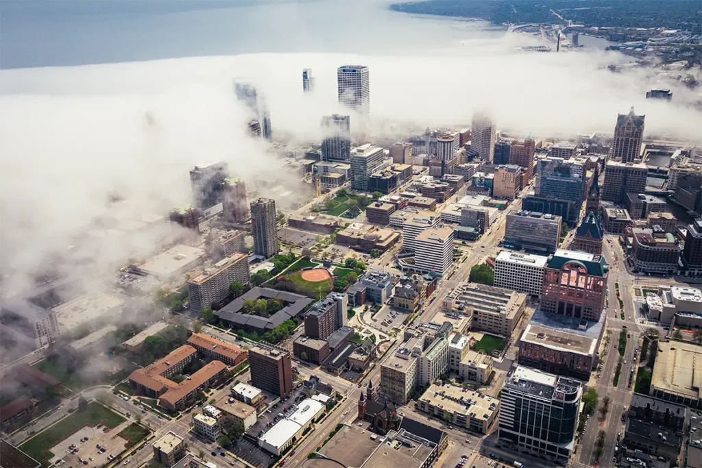 a view of downtown milwaukee from a helicopter while clouds come in from over the water
